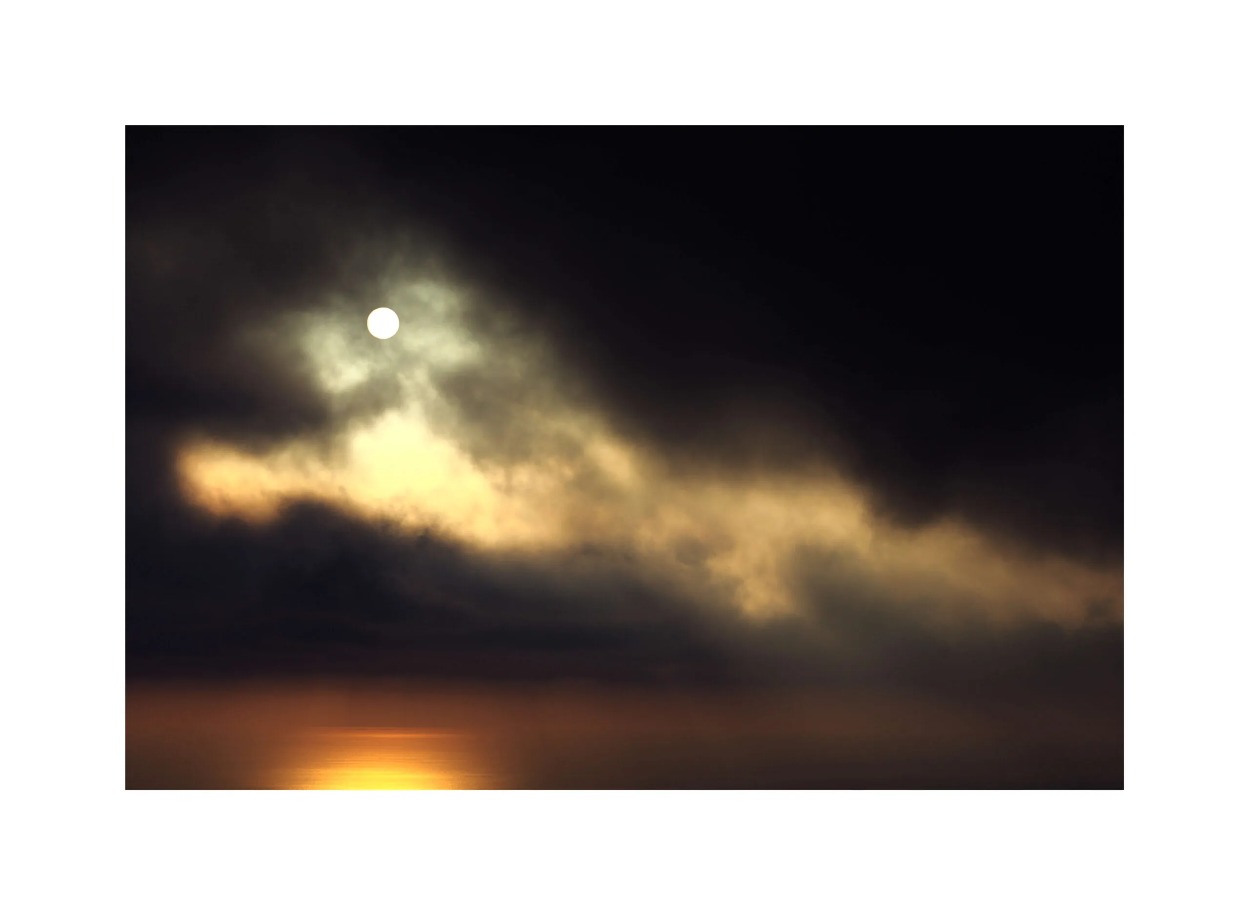 Nuvola dorata luminosa nel cielo scuro, riflesso sull'acqua.